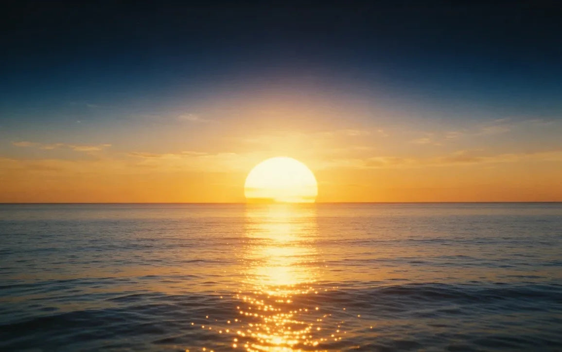 Un lever de soleil sur la mer, le ciel passe du bleu nuit à l'orange
